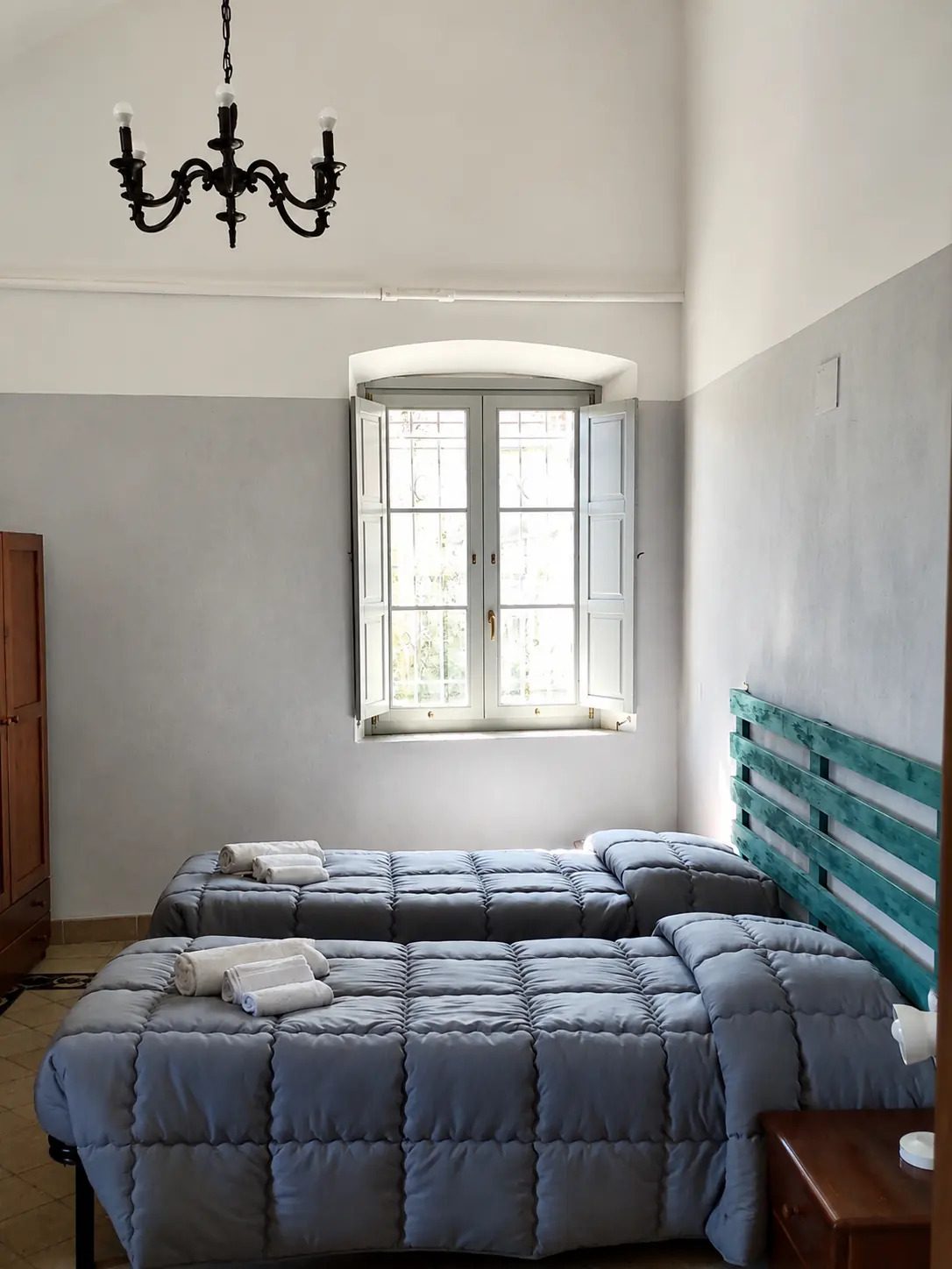 Camera doppia con due letti singoli e soffitto a volte all'ostello Domus Narnia